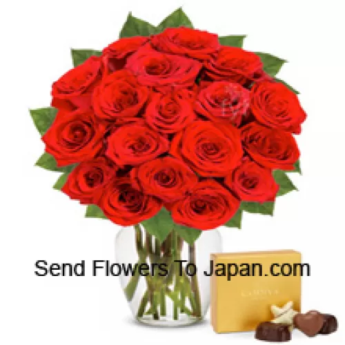 25 roses rouges avec des fougères dans un vase en verre accompagné d'une boîte de chocolats importée