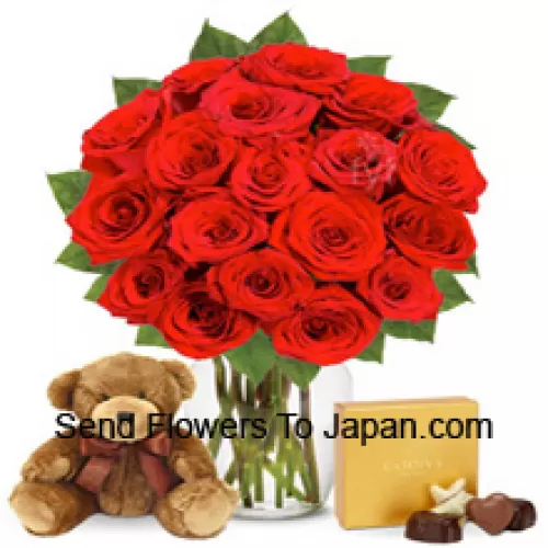 11 roses rouges avec quelques fougères dans un vase en verre accompagnées d'une boîte de chocolats importée et d'un mignon ours en peluche brun de 12 pouces de hauteur