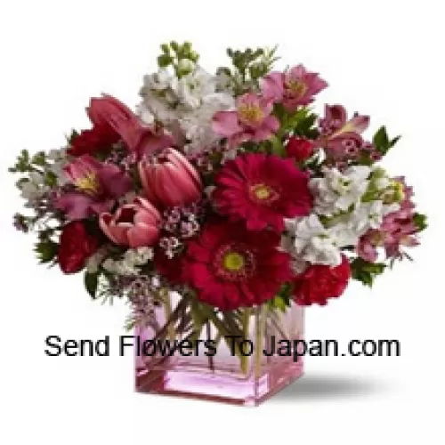 Rote Rosen, rote Tulpen und gemischte Blumen mit saisonalen Füllstoffen, wunderschön in einer Glasvase arrangiert