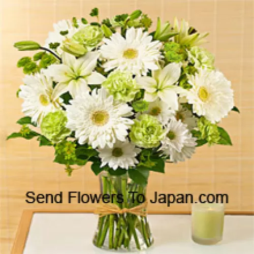 Gerbères blanches, alstroemeria blanches et autres fleurs de saison assorties arrangées magnifiquement dans un vase en verre