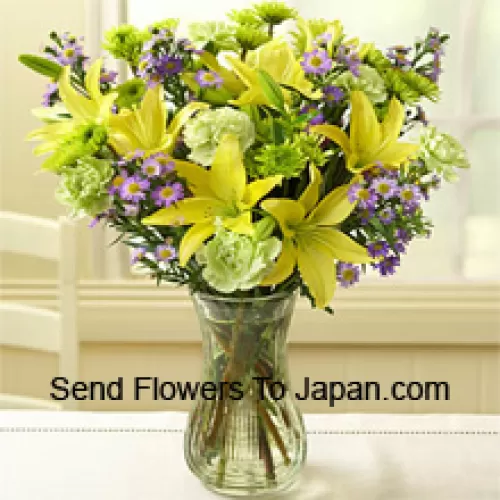 Gelbe Lilien und andere verschiedene Blumen, wunderschön in einer Glasvase arrangiert