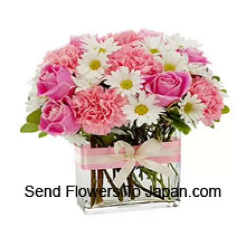 Rose rosa, garofani rosa e fiori bianchi assortiti di stagione disposti splendidamente in un vaso di vetro