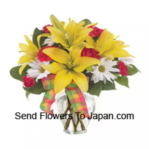 Gigli gialli, garofani rossi e adatti fiori bianchi di stagione disposti splendidamente in un vaso di vetro