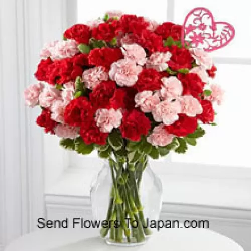 36 Carnations ( 18 Red And 18 Pink ) With Seasonal Fillers And A Heart Stick In A Glass Vase